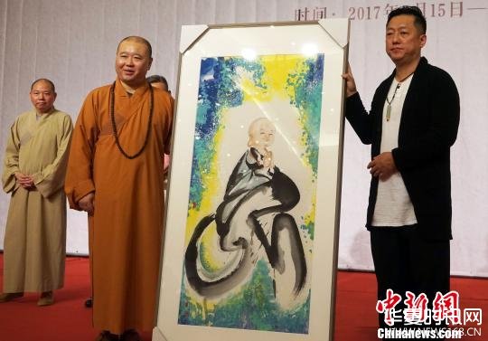 权迎升(右)向上海玉佛禅寺捐赠“禅画小和尚”原创画作一幅。　潘索菲 摄
