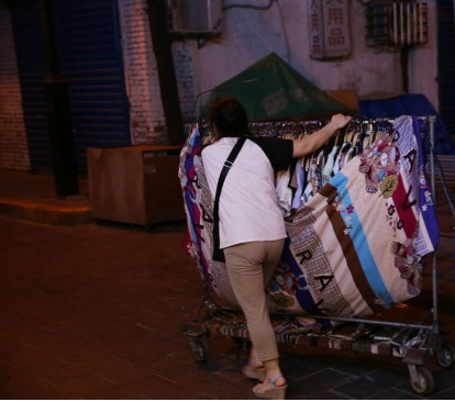 摆摊卖服装的收摊回家