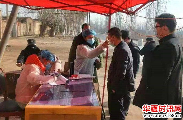 图为阿克苏实验林场党工委的执勤点干部为过往群众测量体温